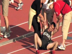 THE AGONY OF VICTORY: Millard West's David Poots needs help getting off the track after he collapsed at the end of his gold medal winning 1600 meter race.